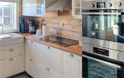 LifjellAmazing Home In B I Telemark With Wifi的厨房配有白色橱柜和炉灶烤箱。
