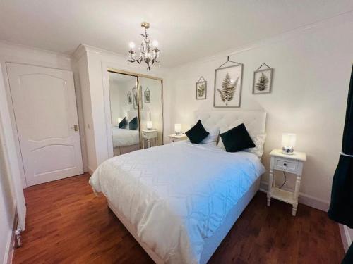 阿伯丁A Stylish Two-Bedroom Flat-Free Parking-CityCentre的卧室配有一张白色大床和吊灯。