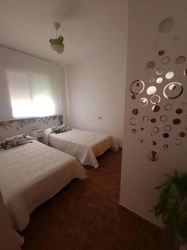 佩尼斯科拉Chalet Edy con piscina的一间设有两张床的房间和一座拥有行星的墙壁