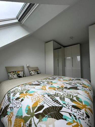 比奇Appartement Nuage blanc的一间卧室配有一张大床和色彩缤纷的毯子