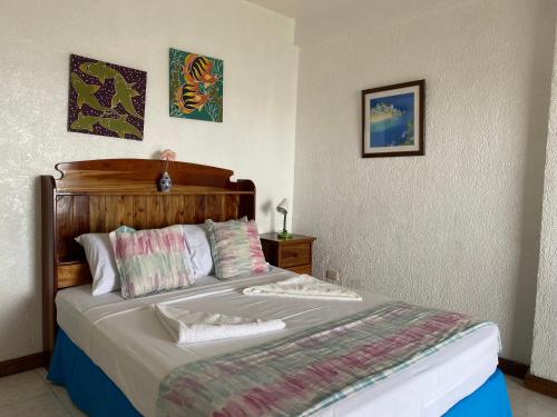 曼巴豪甘米金岛黄金日落海滩俱乐部度假村的一间卧室配有一张大床和木制床头板
