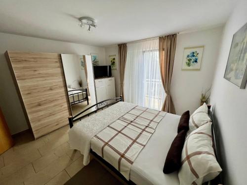 鲁巴达Apartmani Fortuna的一间卧室设有一张大床和一个窗户。