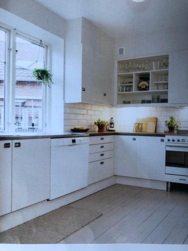 哈尔姆斯塔德Room, central location的白色的厨房配有白色橱柜和窗户