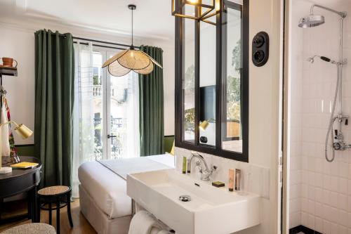 巴黎Avalon Cosy Hotel Paris的浴室设有床、水槽和镜子