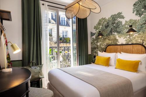 巴黎Avalon Cosy Hotel Paris的一间卧室配有一张带黄色枕头的床和一扇窗户