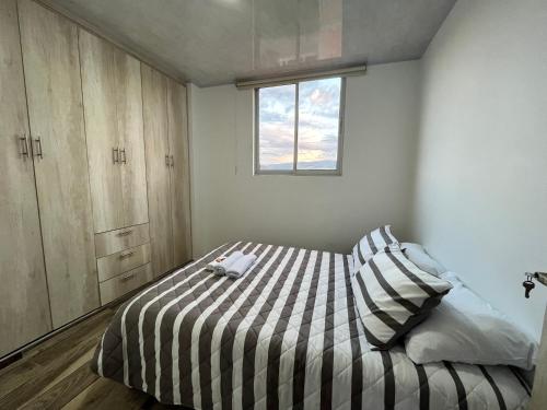 巴尔博萨El Mirador的一间卧室配有带条纹棉被的床和窗户