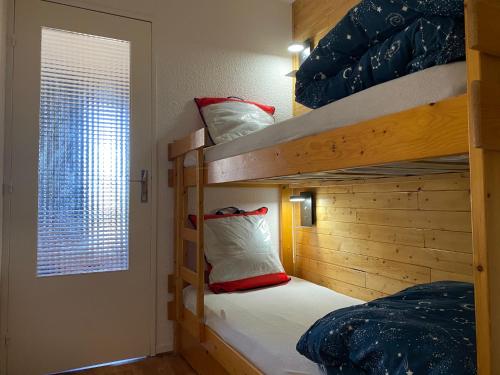 皮伊圣万桑Studio Puy Saint Vincent 1600 aux pieds des pistes的一间卧室设有两张双层床和一扇窗户。