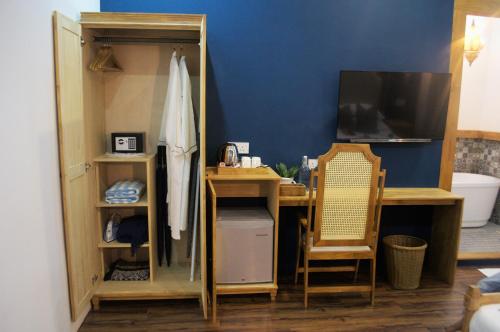 达拉万度Athirige Boutique House Dharavandhoo的客房设有书桌、电视和镜子