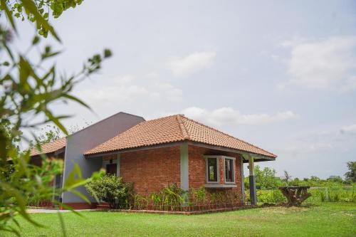 锡吉里亚Foresta Resort Sigiriya的草地庭院里的一个小砖房子