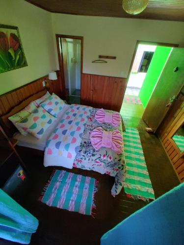 维奥康德马奥Pousada Solar das Flores的卧室配有一张床和枕头,位于地板上