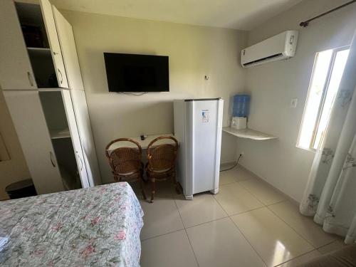塔曼达雷Carneiros Tamandare Apart Hotel Marinas的一间小房间,配有冰箱和两把椅子