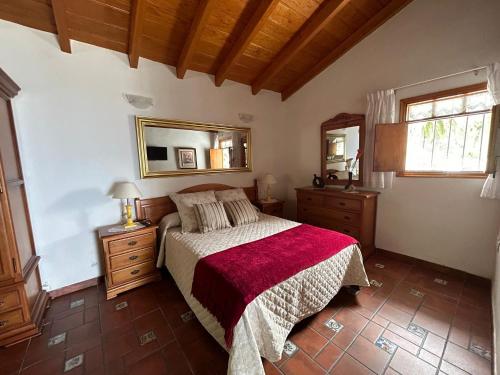 GenovésCasa Rural Los Barros的一间卧室配有一张带红色毯子的床