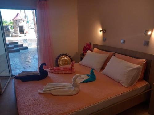 KámposAnemomylos House的一张床上有两只天鹅的睡床