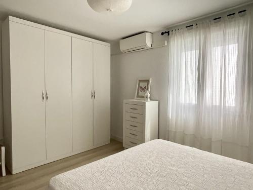 隆达Apartamento Ronda Centro的白色卧室设有白色橱柜和窗户