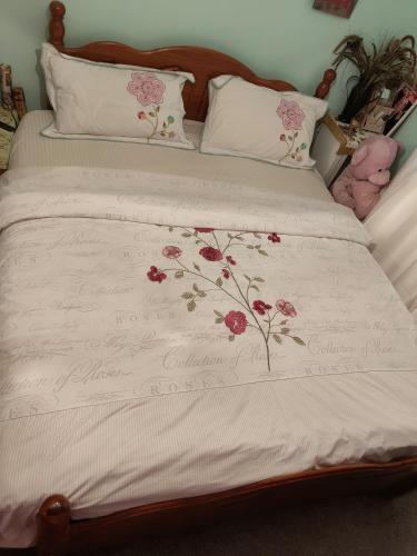 曼彻斯特KEYHAVEN WALK的一张带粉红色花卉的白色棉被的床