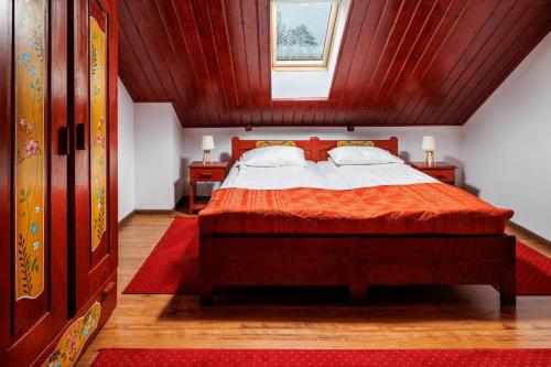 布朗Pensiunea Tanita的一间卧室配有一张红色棉被的床