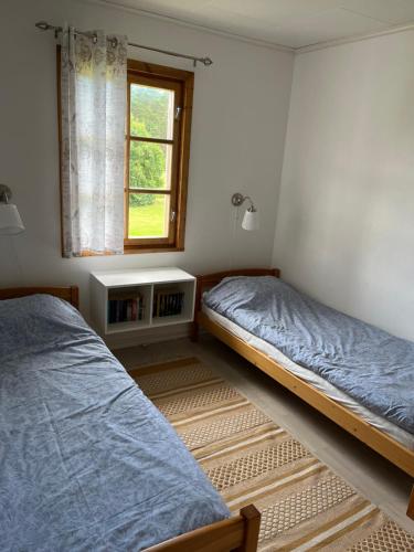 诺鲁迪斯Nya Matsas的一间卧室设有两张床和窗户。