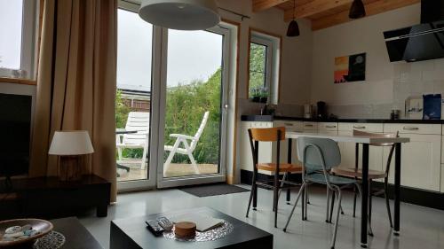 沃尔弗哈Huisjedelinde的厨房设有桌子和椅子,毗邻窗户