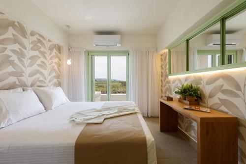 米科利维亚Plioni Villas & Suites的一间卧室配有一张带镜子的床和窗户
