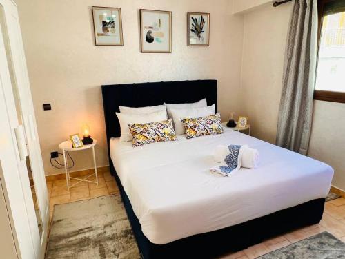 拉巴特Appartement Cosy quartier chic de Rabat的卧室配有带枕头的大型白色床