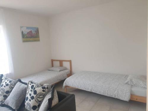 斯尼纳2 room apartment in Snina的一间卧室配有两张床和一张沙发。