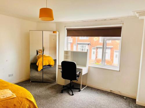 利兹Private Room close to Leeds University and City centre的一间卧室配有书桌、一张床和镜子