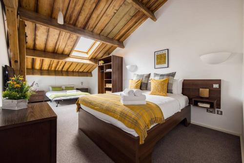 伦敦Wild Roses Serviced Apartments - ExCel Warehouse 2的一间卧室设有一张带木制天花板的大床