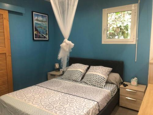 圣安尼Kaz bleu karaibes的蓝色的卧室设有床和窗户