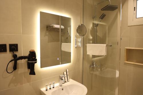 泰布克نيلوفر - Nilover的浴室配有盥洗盆和带镜子的淋浴