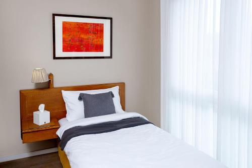科隆里吉纳加尼科隆酒店的卧室配有一张床,墙上挂着一幅画