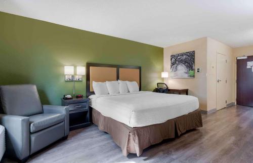 普莱森特希尔美国宜居酒店 - 喜山 - 巴斯柯克大道。的配有一张床和一把椅子的酒店客房