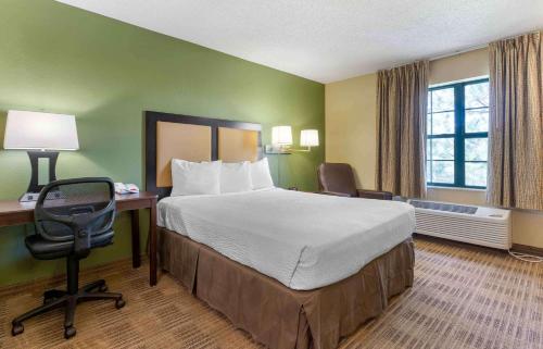 利弗莫尔美国利弗莫尔机场长住酒店的酒店客房设有一张大床、一张桌子和椅子。