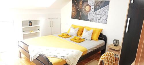 阿然德洛维克Apartman Blagojevic Hill的一间小卧室,配有一张带黄色枕头的床
