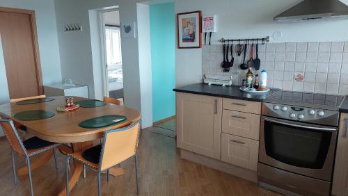 欧拉夫斯维克Olafsvik Guesthouse的厨房配有木桌、桌子和炉灶。