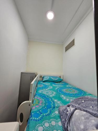 迪拜SKY 9 Hostel的小卧室配有一张带绿毯的床