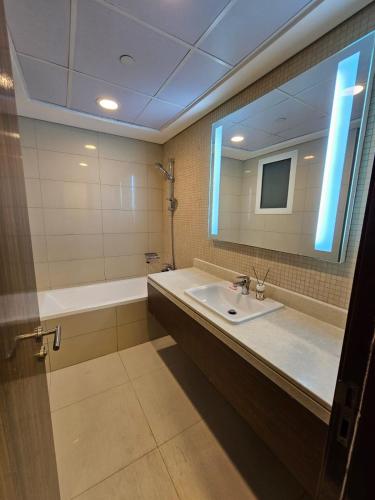 迪拜SKY 9 Hostel的一间带水槽、浴缸和镜子的浴室