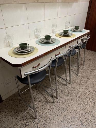 圣保罗Suíte Próxima Ao Metrô Penha !!!的一张桌子,上面有四把椅子和盘子