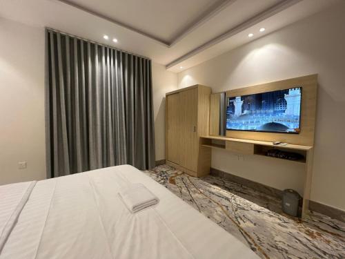 AR Rummanahسويت إم للأجنحة الفندقية的酒店客房,配有床和电视