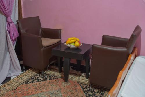 瓦尔扎扎特Riad Dar Fadma的一张桌子,上面有两把椅子和一碗水果