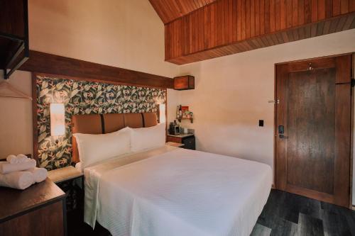 福尔图纳Suwa Villa Arenal的卧室配有白色的床和木门