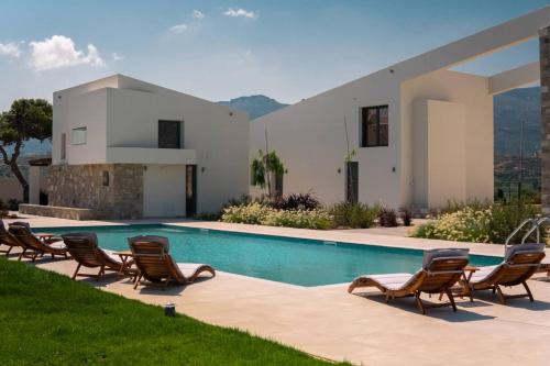 锡蒂亚Itida Suites的别墅 - 带带椅子的游泳池和房屋