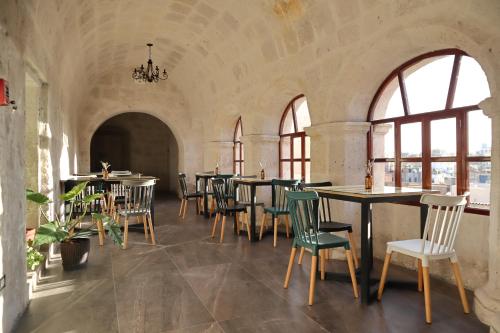阿雷基帕Estancia El Solar的一间设有桌椅的餐厅,位于带窗户的房间内