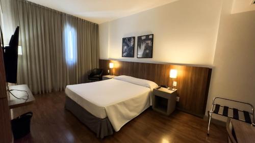 贝洛奥里藏特Hotel Vivenzo Savassi Belo Horizonte的酒店客房设有白色的床和窗户。