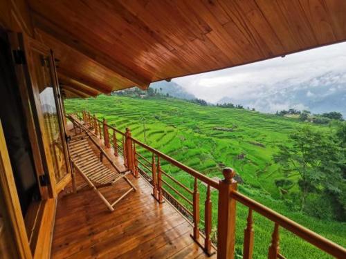 萨帕Hmong Eco Villas的阳台享有绿色田野的景色。