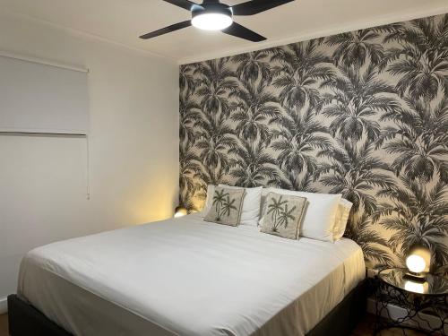 凯恩斯Il Palazzo Holiday Apartments的一间卧室配有一张带壁纸的大床