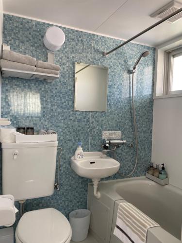 座间味村Dining & Stay 38 Miyahira的浴室配有卫生间、盥洗盆和浴缸。