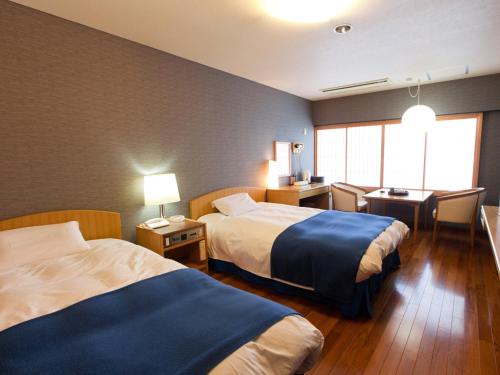 高知三翠园酒店的酒店客房配有两张床和一张书桌
