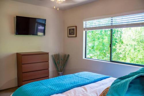 塞多纳Carnelian Coyote - Fabulous Condo in West Sedona!的一间卧室设有一张床、一台电视和一个窗口。