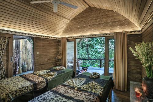 帕洋安Sacred Canyon Ubud by Pramana Villas的一间卧室设有两张床和大窗户