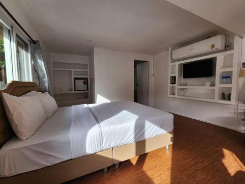 Tha KradanLake Hill Resort Kanchanaburi的卧室配有一张白色大床和电视。